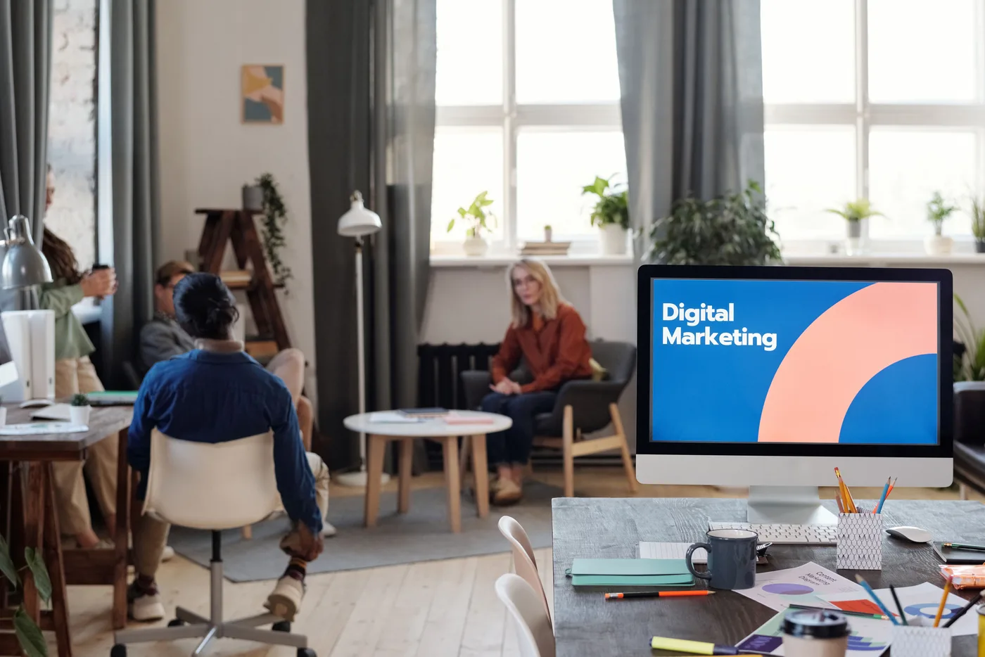 Marketing team analyzing campaign performance data on screens in an office
