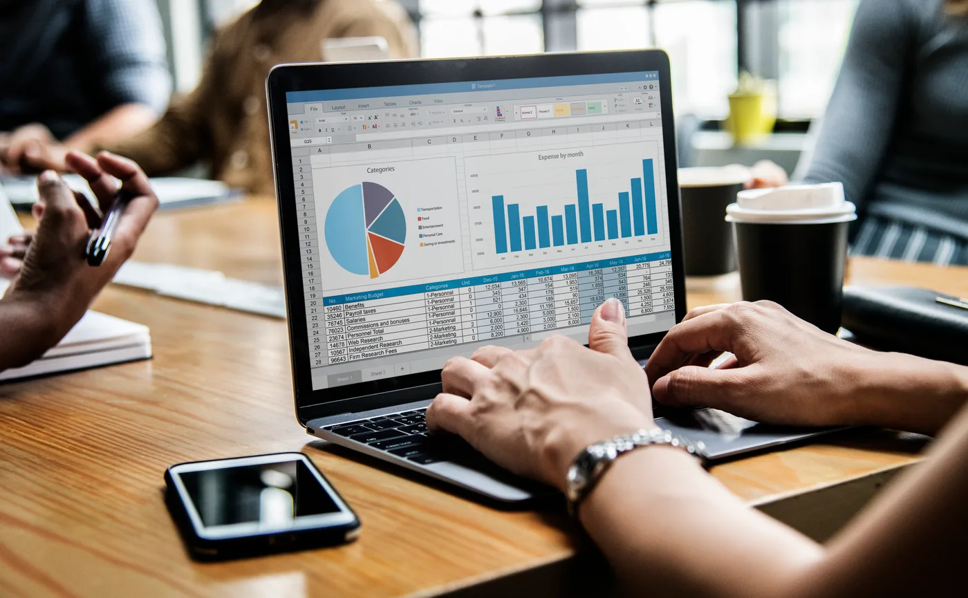 Business owner reviewing social media marketing performance on smartphone and laptop